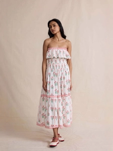 Elegant ivory floral maxi dress with ruffle neckline and smocked waist on a model