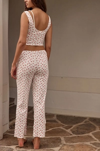 Detail view of ribbed knit two-piece set featuring delicate red floral print on white fabric