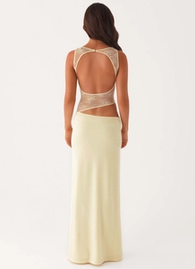 Detail of a cream lace maxi dress featuring an open back and cutout waist design