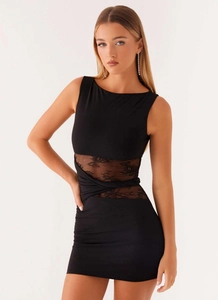 Détail d'une robe moulante noire sans manches avec dentelle et découpes à la taille