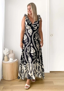 Detail of V-neck sleeveless maxi dress with black and white leaf print and bow straps