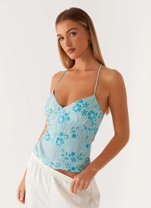 Détail du haut bleu clair à fines bretelles avec paillettes florales et broderies de perles