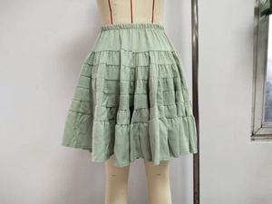 Detail of light green tiered skirt showing layered ruffles and elastic waistband