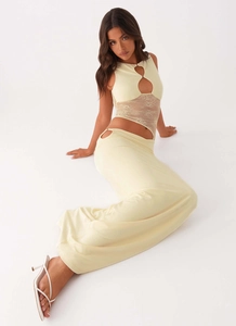 Detail of light yellow two-piece set featuring lace cutout top and slim fit maxi skirt