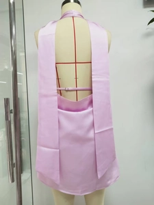 Detailed back view of pink satin halter dress featuring an open back and silk texture