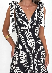 Detail of deep V-neckline with tropical print and adjustable bow shoulder straps