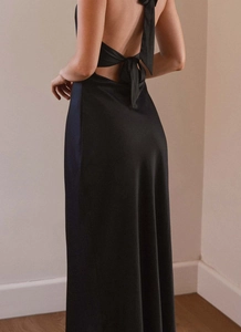 Detail view of backless black satin dress with elegant double bow ribbons on the back