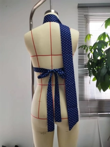 Detail eines dunkelblauen gepunkteten Schals, der als Neckholder-Top gebunden ist