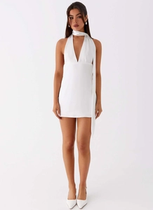 Detail of white halter neck mini dress with deep V-neckline and satin finish texture
