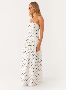 Detail of bohemian strapless maxi dress featuring classic black polka dots on white fabric