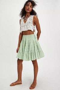 Close-up of light green bohemian tiered skirt with elastic waist and ruffle details