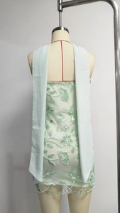 Close-up of mint green tulle dress featuring floral embroidery and white beadwork details