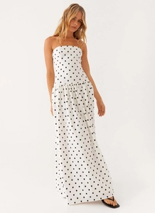 Detail view of white strapless maxi dress with black polka dots and pleated hemline
