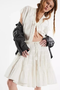 Close-up of white bohemian tiered skirt with delicate lace splicing and layered ruffles