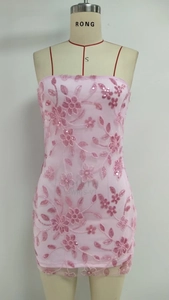 Close-up of pink sequin floral embroidery and mesh texture on mini tube dress