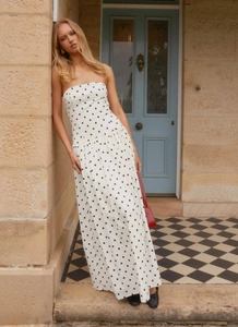 Detail of bohemian strapless long dress with black polka dots on white fabric