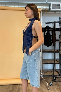 Seitenansicht des blauen Polka-Dot-Halter-Tops mit rückenfreiem Design und Nackenband