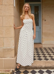 Detail of bohemian strapless white maxi dress with black polka dots on cotton-linen fabric