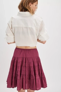Detail view of burgundy tiered ruffle maxi skirt back design with white long sleeve shirt