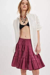 Detail of tiered burgundy cake skirt with drawstring tassels and textured fabric