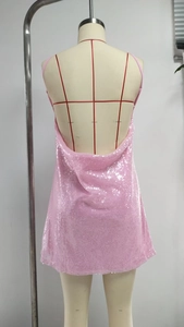 Detail of pink sequin dress featuring a deep V backless design and thin straps