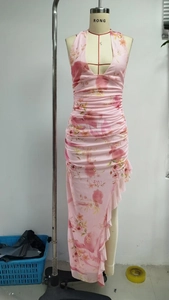 Detail of pink floral halter dress showing deep V-neckline and ruffled asymmetric hemline