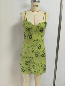 Close-up of vibrant green slip dress with intricate floral sequin and bead embroidery