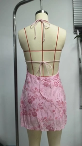 Détail d'une mini robe Y2K rose avec broderies florales, paillettes et franges de perles