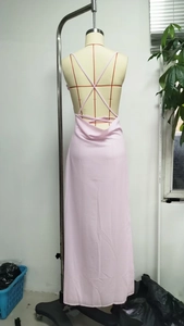 Detail view of light pink backless maxi dress with crisscross straps and draped open back