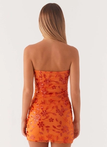 Detail of back view showing sequin floral embroidery on a strapless orange bodycon dress
