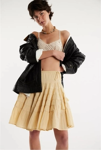 Detail of white tiered ruffle skirt featuring elastic waist and tassel drawstring detail