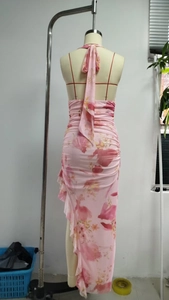 Detail of pink floral halter dress featuring backless tie-up design and ruffled hemline