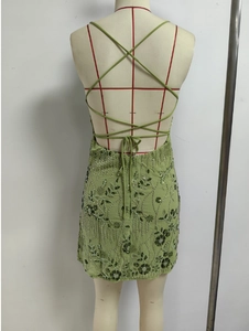 Detail of light green sequin beaded mini dress showing criss-cross tie back design