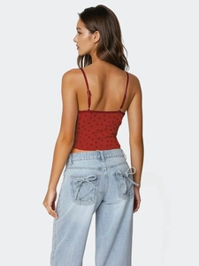 Vue arrière d'un caraco rouge à cœurs et d'un jean bleu clair avec détails à lacets
