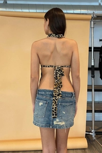 Rückansicht eines Neckholder-Tops mit Leopardenmuster und Bindedesign mit Jeansrock