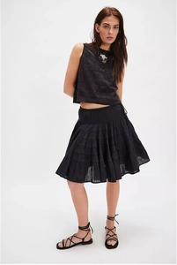 Detail of black embroidered sleeveless top and layered ruffle skirt in boho style