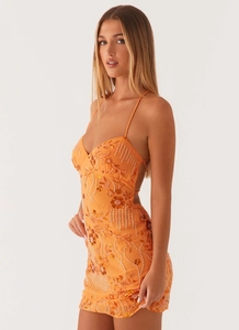 Close-up of intricate hand-beaded orange sequins and floral patterns on the party dress