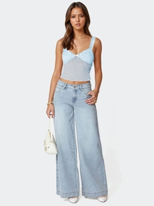 Détail d'un crop top en dentelle bleu clair avec motifs cœurs et petit nœud délicat