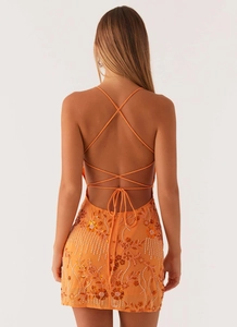Detail of orange sequined dress with beadwork and open back cross lace-up design