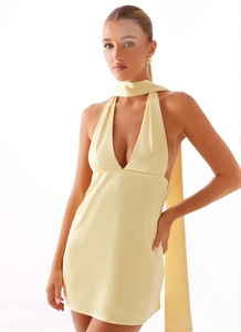 Macro detail of pale yellow satin mini dress featuring deep V-neck and matching neck scarf
