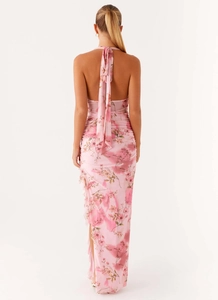 Rear view of pink floral halter dress showing backless cut and ruffled split hem