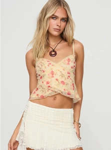 Detail of floral camisole top featuring red print and delicate lace trim edges