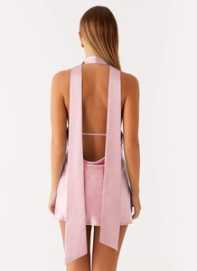 Back view of elegant light pink satin dress featuring a deep U-shaped backless design