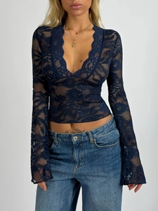 Détail du haut en dentelle bleu marine avec motifs floraux complexes et décolleté en V chic