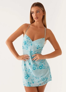 Close-up detail of blue floral beadwork and white sequins on a mini strap dress