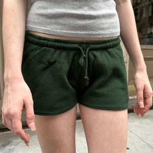 Detail der Waffelstrick-Struktur bei dunkelgrünen Freizeit-Shorts mit Kordelzugbund