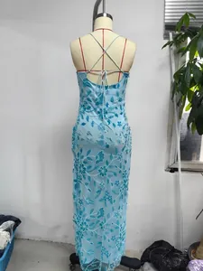 Close-up of intricate floral embroidery and beadwork on a light blue backless dress