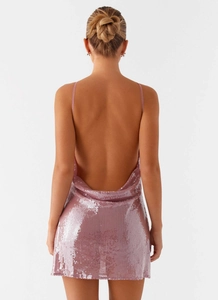 Detail of a pink sequin backless mini dress with delicate straps and reflective texture