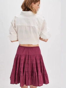 White long sleeve shirt paired with a tiered wine red cake skirt for a stylish summer look