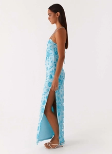 Detail of light blue sequin floral embroidery and high side slit on an elegant maxi dress